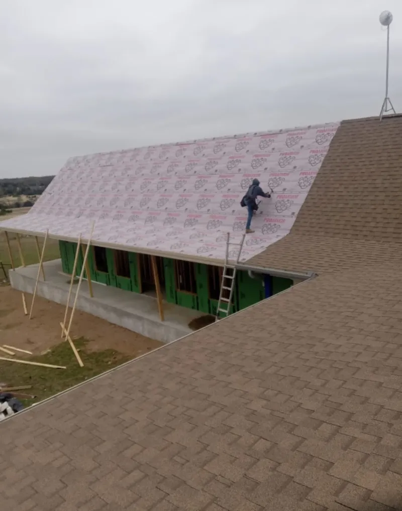 Worker preparing underlayment for a metal roof installation in Youngtown